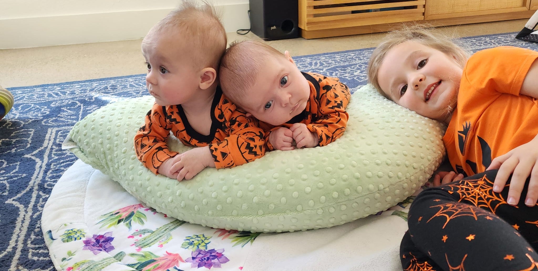 Babies using luna lullaby nursing pillow as a tummy time support