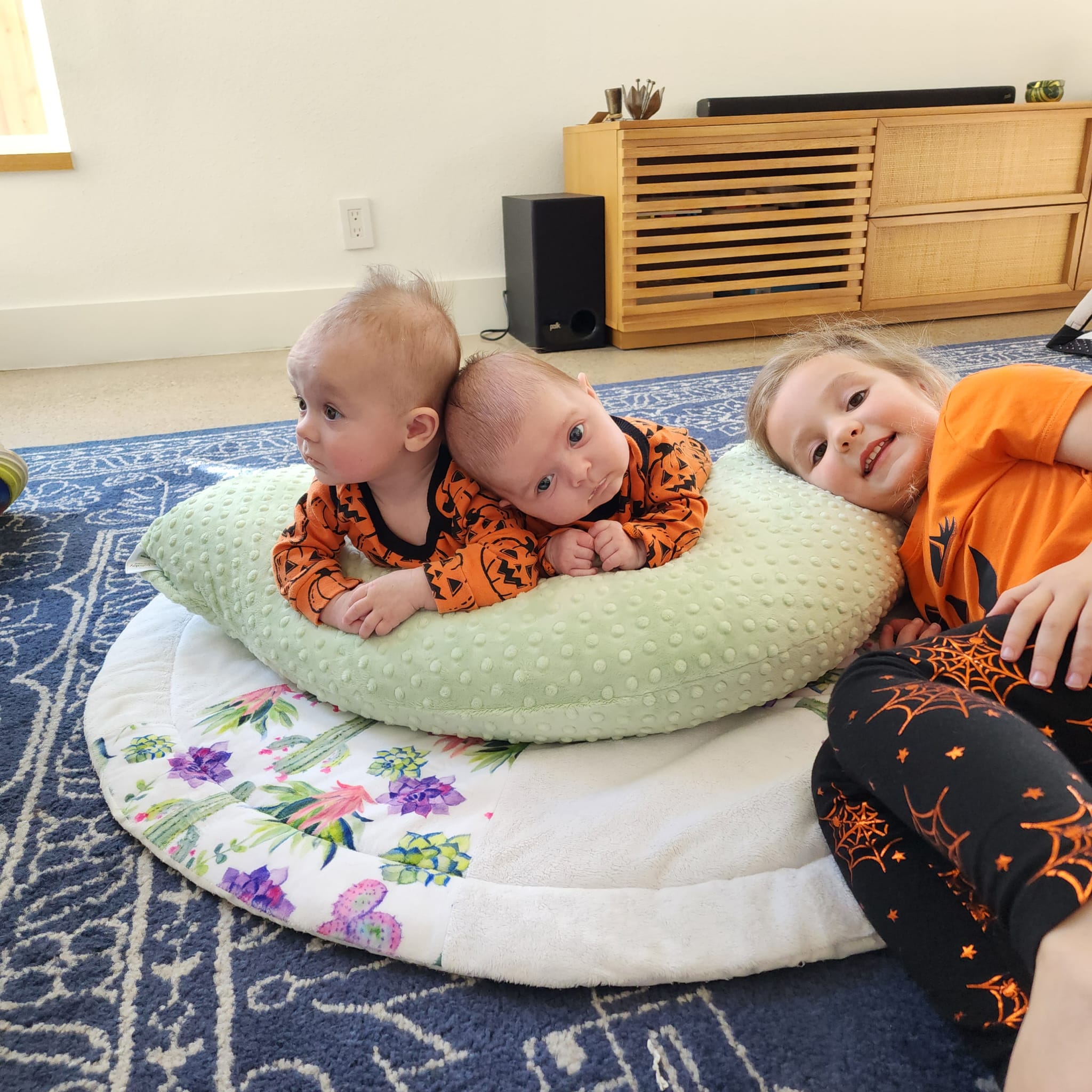 Babies using luna lullaby nursing pillow as a tummy time support