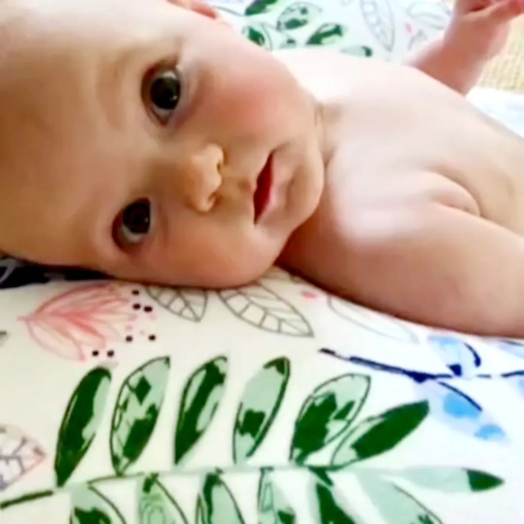 Baby being supported during playtime on luna lullaby nursing pillow