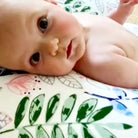 Baby being supported during playtime on luna lullaby nursing pillow